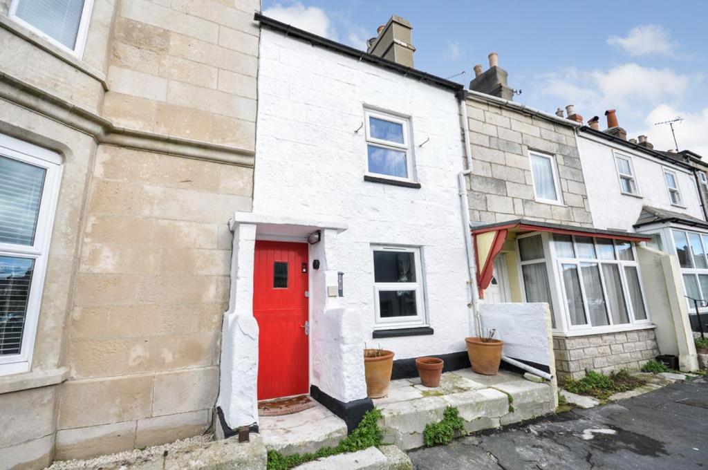 a white brick house with a red door at Duke’s Cottage in Portland