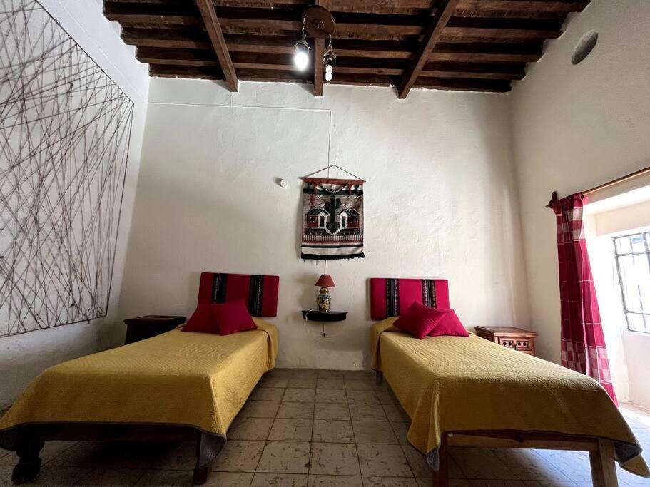 a room with two beds with red pillows at Casa colonial céntrica Guanajuato in Guanajuato