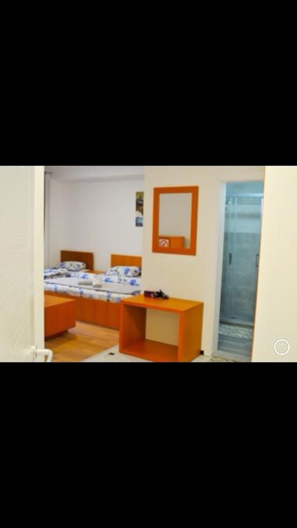 Cette chambre comprend 2 lits et une table. dans l'établissement Welcome&Enjoy 2, à Ohrid
