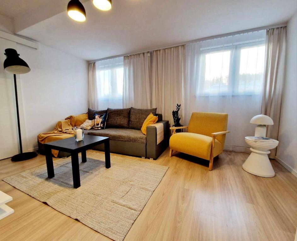 a living room with a couch and a table and a chair at Apartamencik Słoneczny in Kamienna Góra