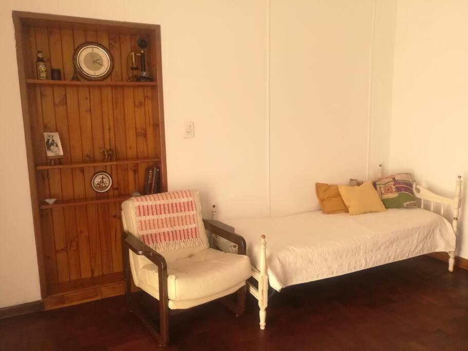 a small bedroom with a bed and a chair at CasitaLibertad 