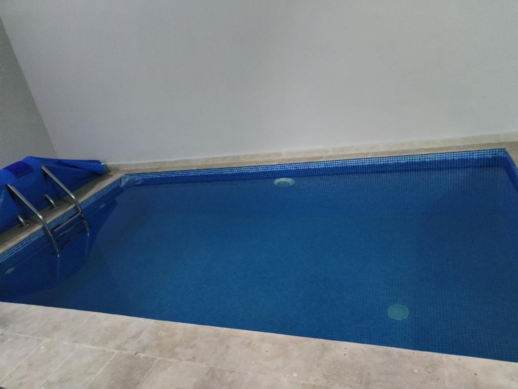 einen Pool mit blauem Wasser in einem Zimmer in der Unterkunft شقة رائعة داخل فيلا مستقلة in Casablanca