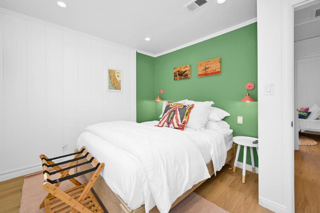 ein Schlafzimmer mit einem weißen Bett und grünen Wänden in der Unterkunft Chic Modern Designed Home with Private Studio in Newport Beach