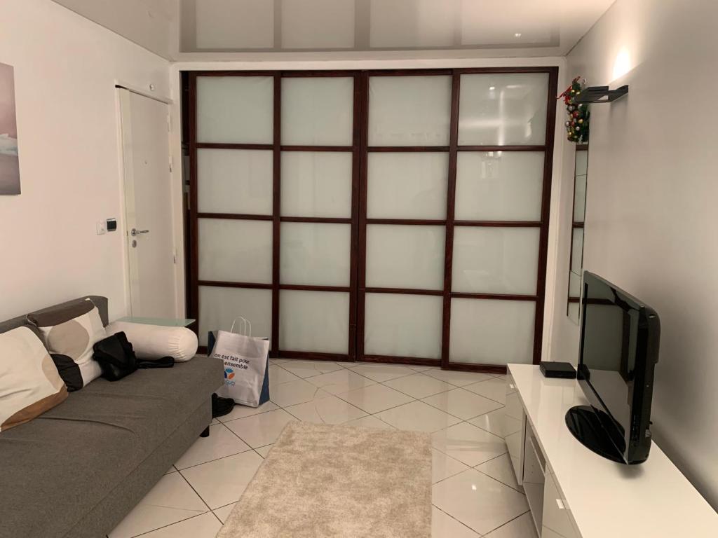 un salon avec un canapé et une télévision dans l'établissement Mignonne, à Paris