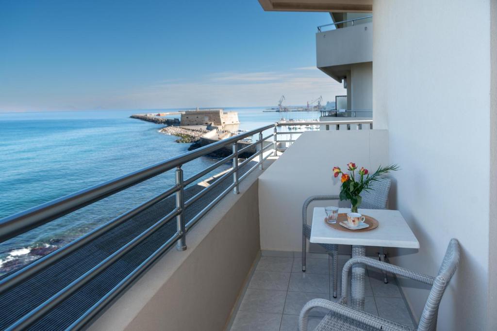 a balcony with a table and a view of the ocean at Kronos Hotel in Heraklio Town