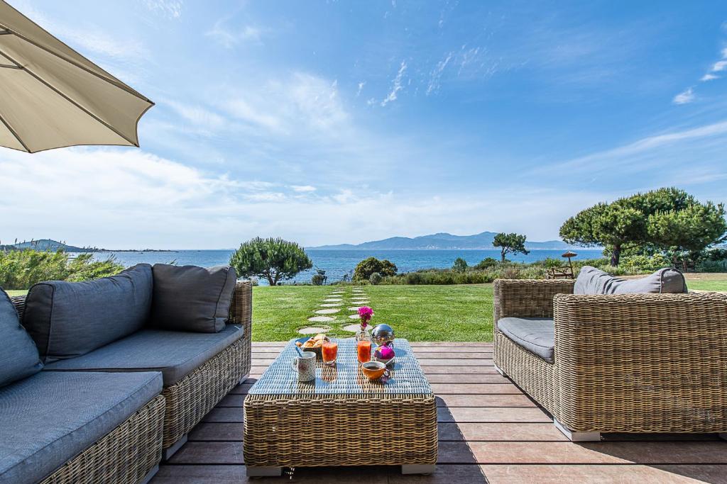 un patio con 2 sofás y una mesa de cristal en Villa HAPPY DAYS, en Pietrosella