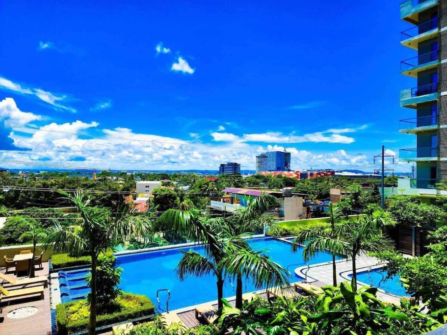 Blick auf ein Resort mit Pool und Palmen in der Unterkunft Cozy condo unit at The Palladium in Iloilo City