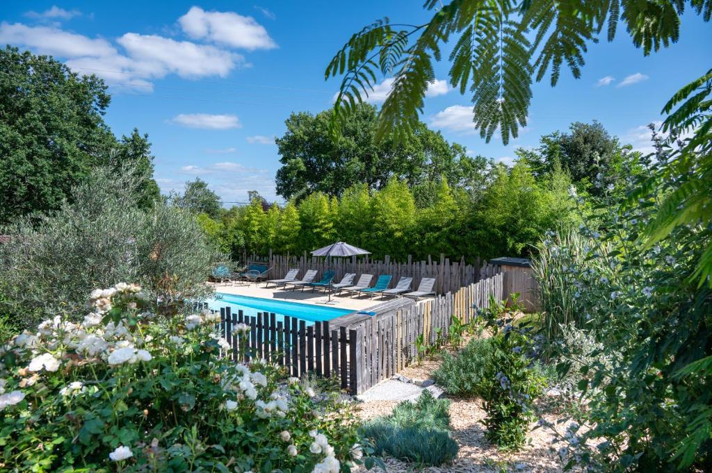 un jardín con piscina y una valla de madera en L'Escapade Nature et Gourmande Piscine et Clim Toulouse et Colomiers Airbus Gers gîte Bouconne, en Pujaudran
