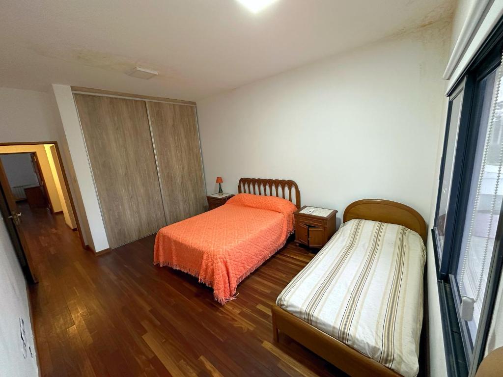 ein Schlafzimmer mit einem Bett mit einer orangefarbenen Bettdecke in der Unterkunft Casa familiar Nivel Superior in San Fernando del Valle de Catamarca