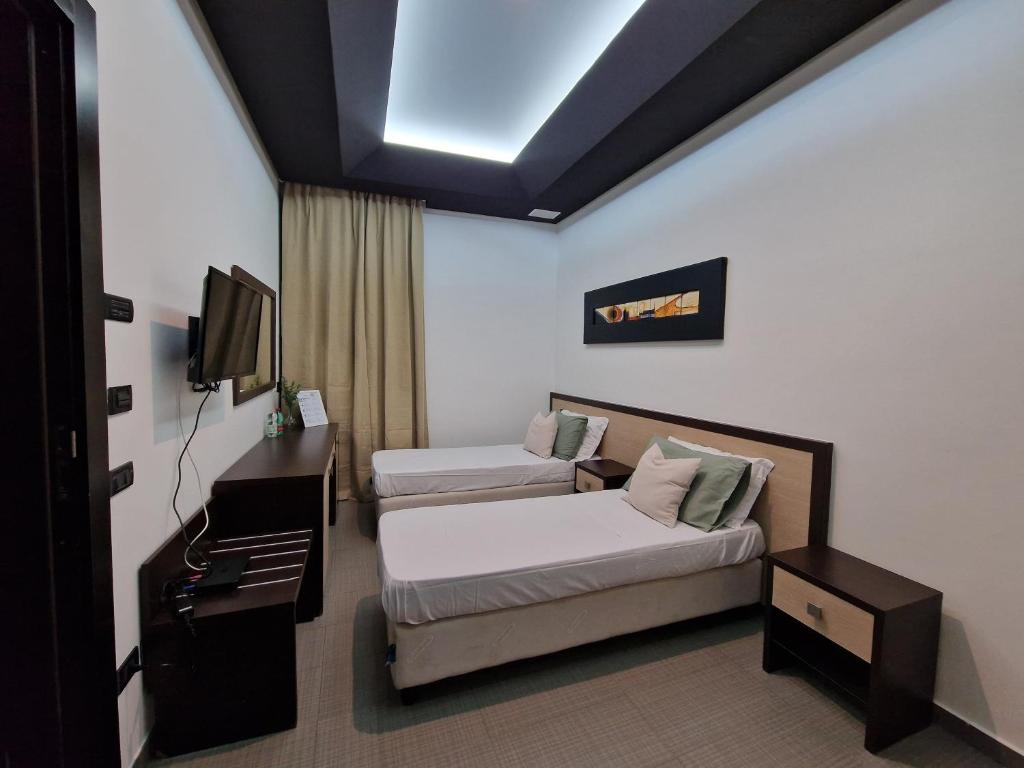 Cette chambre comprend un lit, un canapé et une télévision. dans l'établissement Boteco B&B, à Bacoli