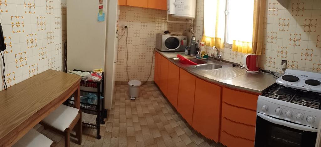 a small kitchen with a sink and a stove at Frente al mar in Mar del Plata