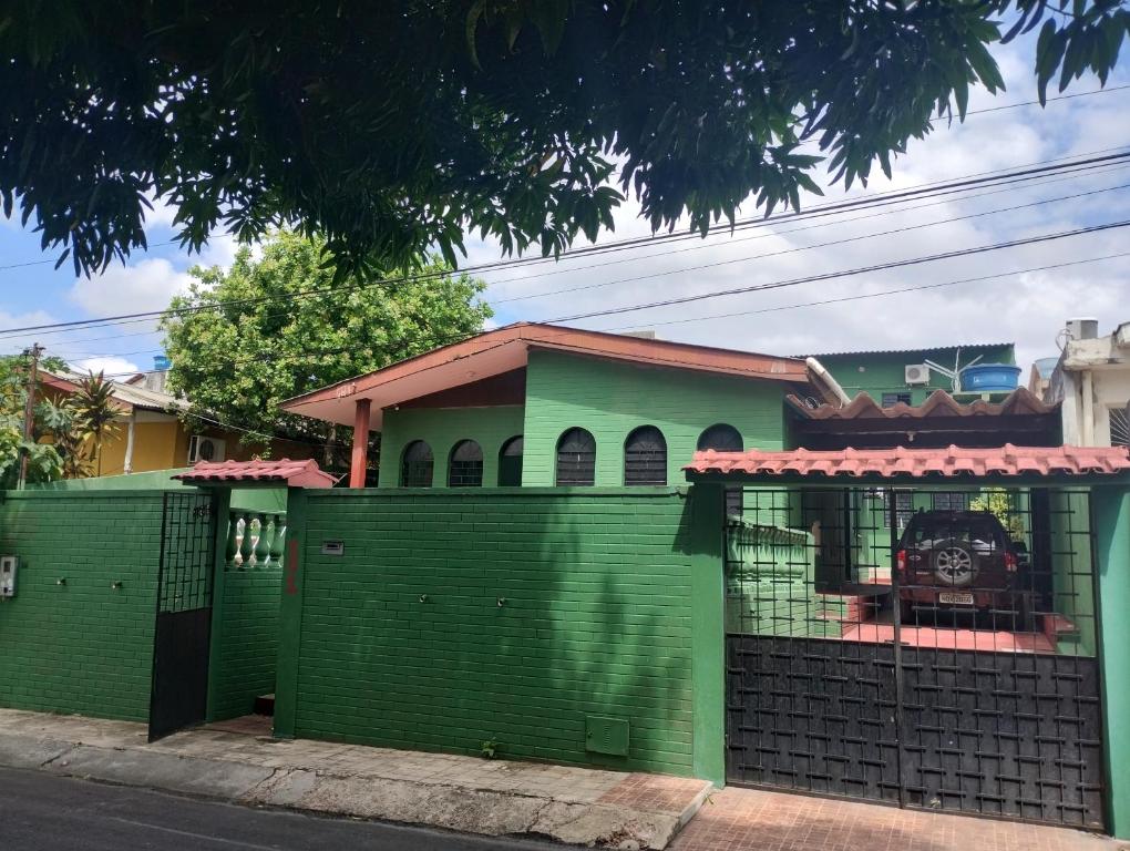 una valla verde frente a una casa en Residencial Andréa House, en Manaus