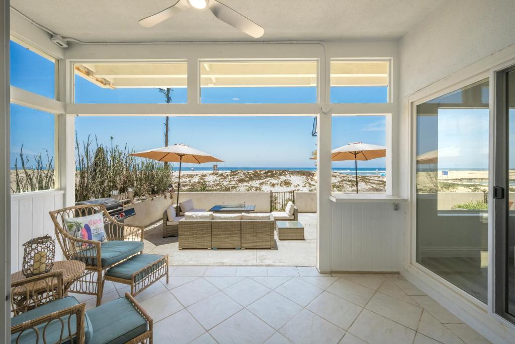 a living room with a patio with a view of the ocean at 6 Bedroom Remodeled Home on the Oceanfront in Newport Beach