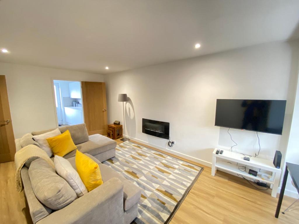 a living room with a couch and a flat screen tv at Cosy Retreat In Royal Sutton Coldfield Close to Good Hope Hospital the NEC and Birmingham Airport in Birmingham