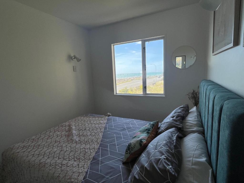a bedroom with a bed and a window at Kaikoura Seaside lodge in Kaikoura