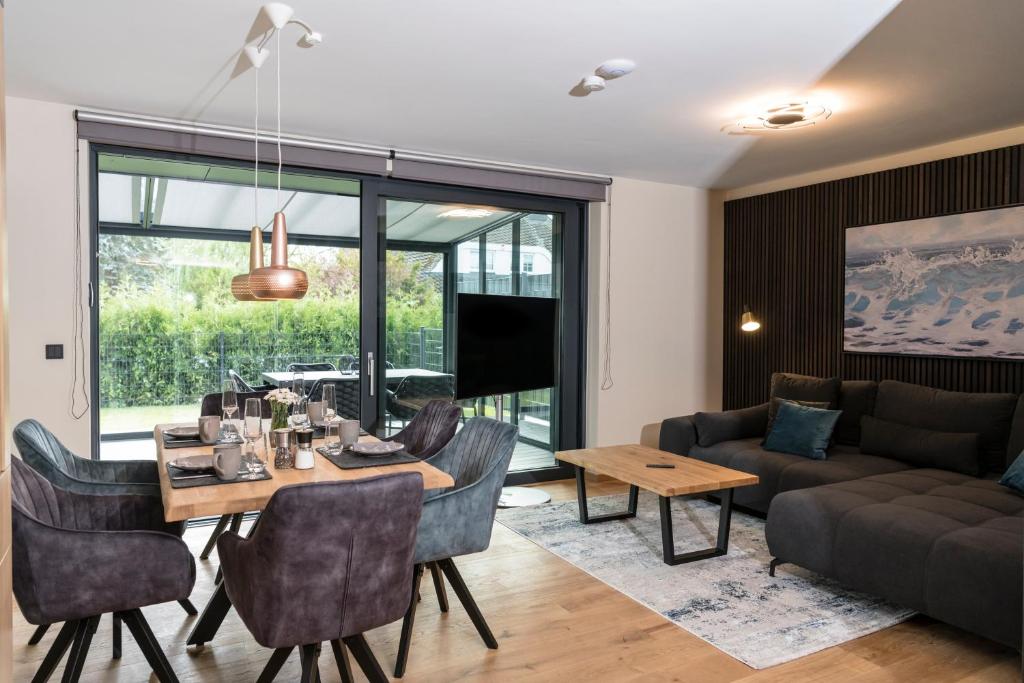 a living room with a table and a couch at Wellness House Oase Spa mit Whirlpool in Timmendorfer Strand