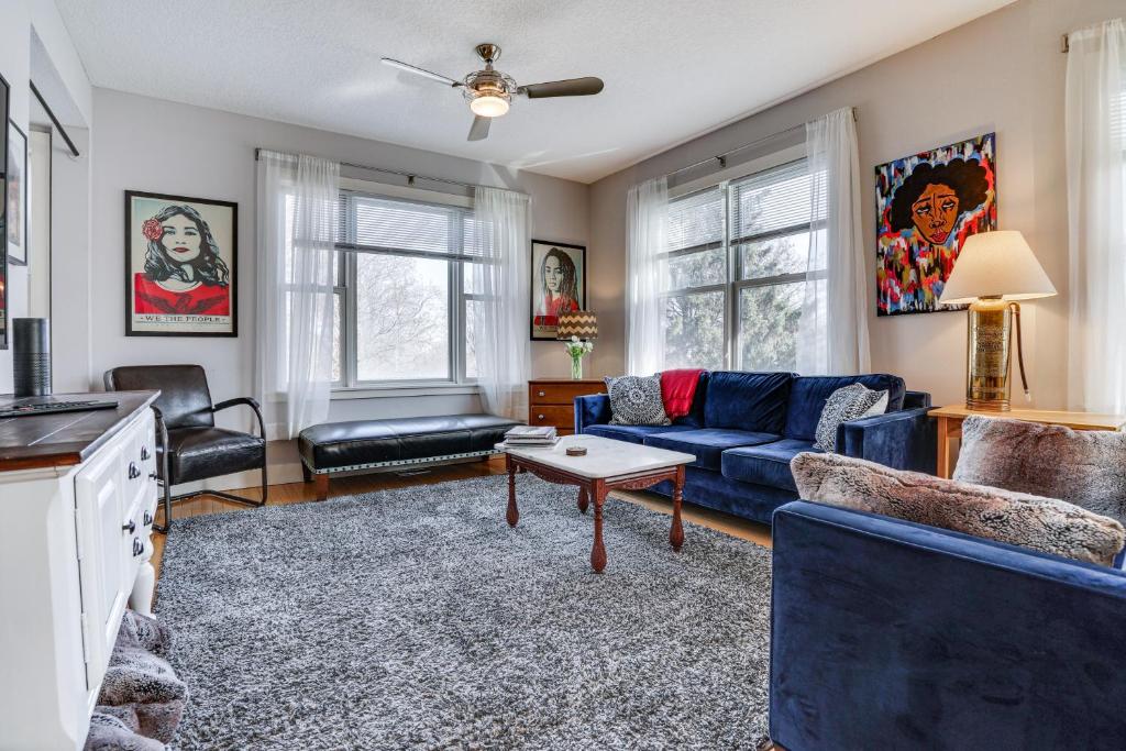 a living room with a blue couch and a table at Pet-Friendly Saint Paul Vacation Rental with Deck! in West Saint Paul