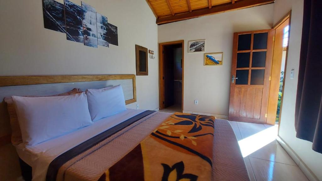 a bedroom with a bed in a room at Pousada Portal da Serra - Chalés in Carrancas