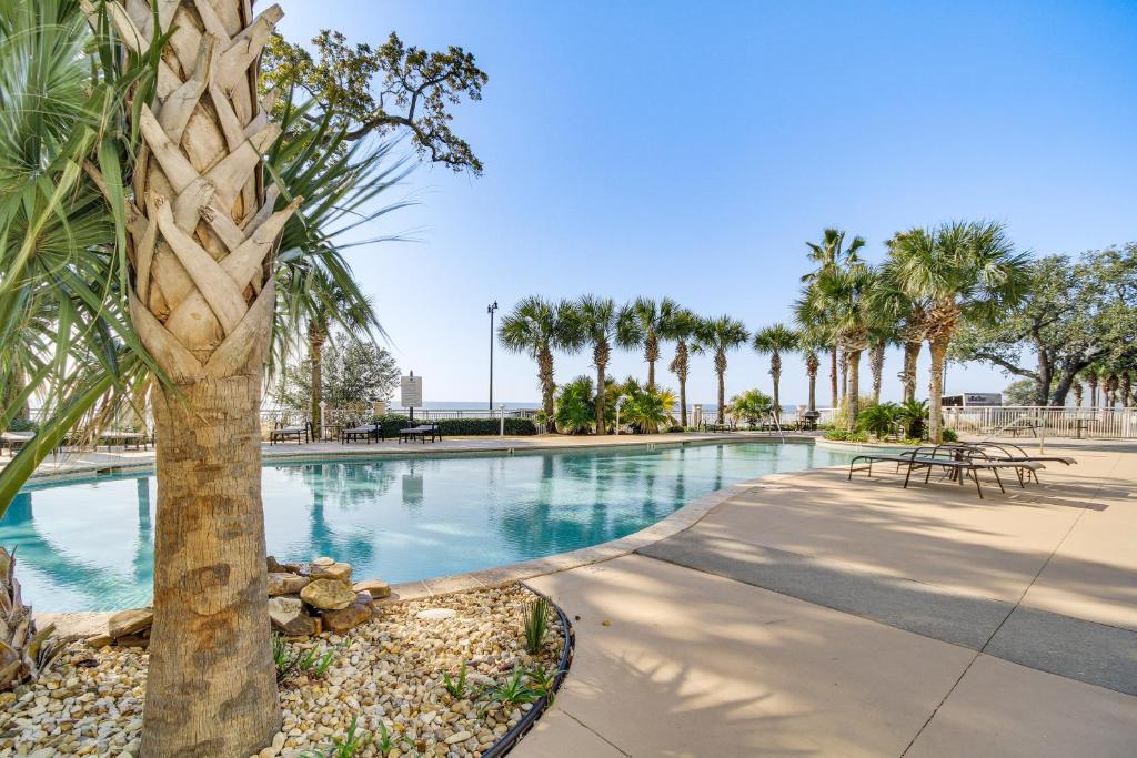 einen Pool mit einer Palme in einem Resort in der Unterkunft Charming Gulfport Condo - Walk to Beach Access! in Gulfport
