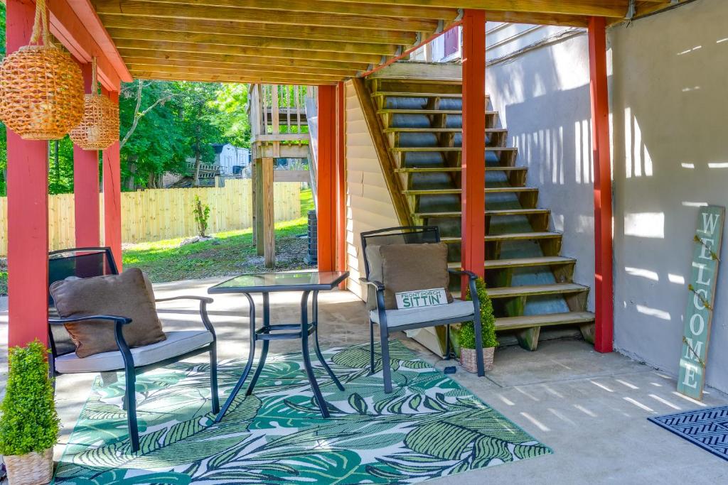 a patio with two chairs and a table and a staircase at District Heights Apartment with Patio and Seating in District Heights