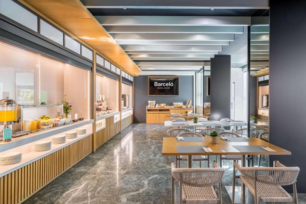 a restaurant with tables and chairs and a counter at Barceló Murcia Siete Coronas in Murcia