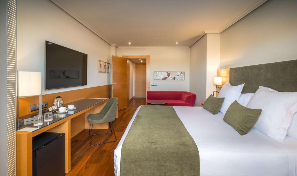 a hotel room with a large bed and a desk at Barceló Murcia Siete Coronas in Murcia