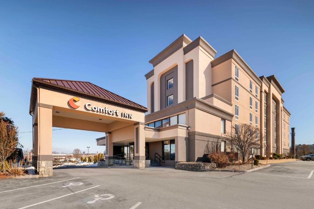 a building with a car dealership in front of it at Comfort Inn Airport in Manchester