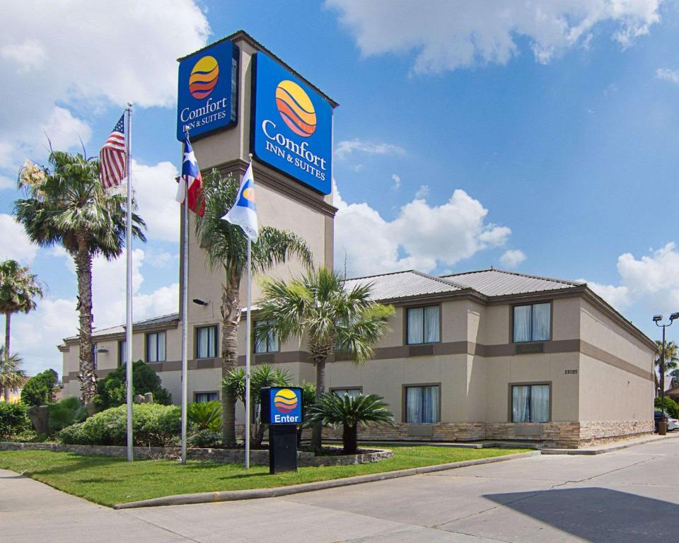 een vooraanzicht van een hotel met vlaggen aan de voorzijde bij Comfort Inn & Suites Houston West-Katy in Katy