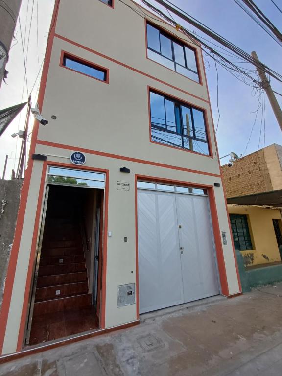 una casa con dos puertas de garaje delante de ella en Cardos hostal, en Pisco