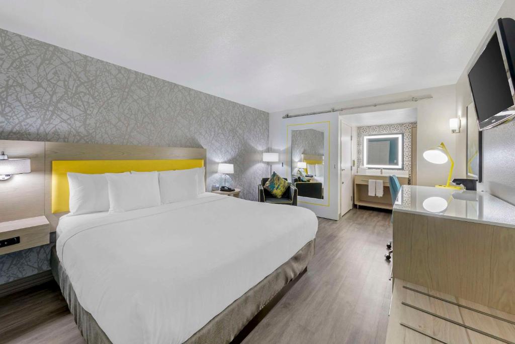 a hotel room with a large bed and a desk at Hillstone Inn Tulare, Ascend Hotel Collection in Tulare
