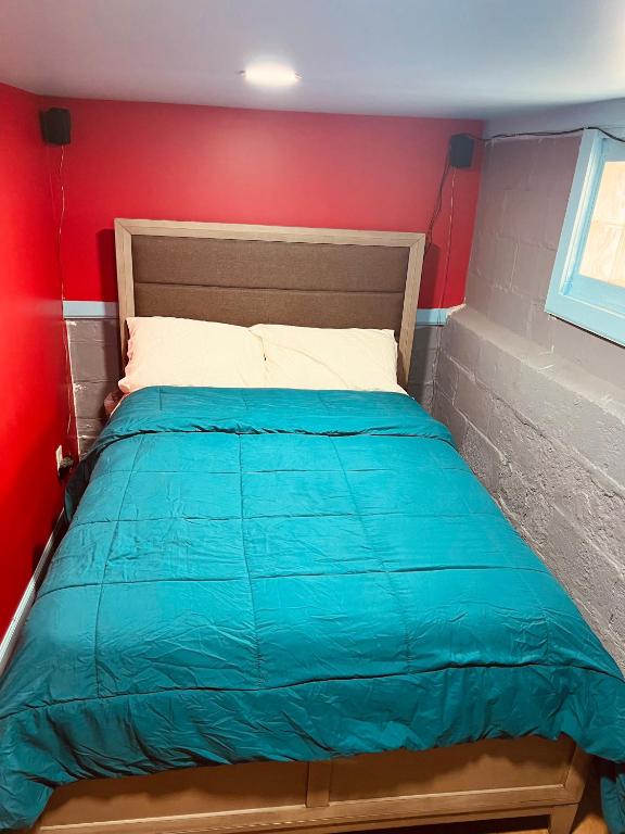 uma cama num quarto com uma parede vermelha em Private Room with Bathroom & Entrance em Irvington