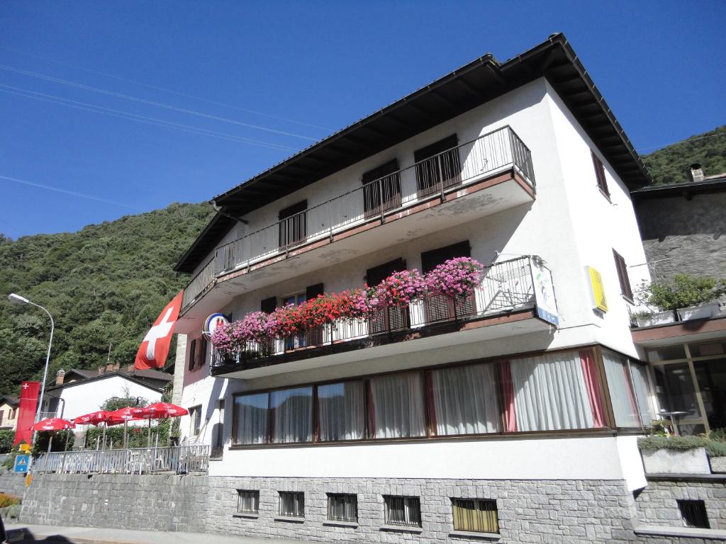 un edificio blanco con flores en los balcones en Ristorante Vedeggio, en Isone