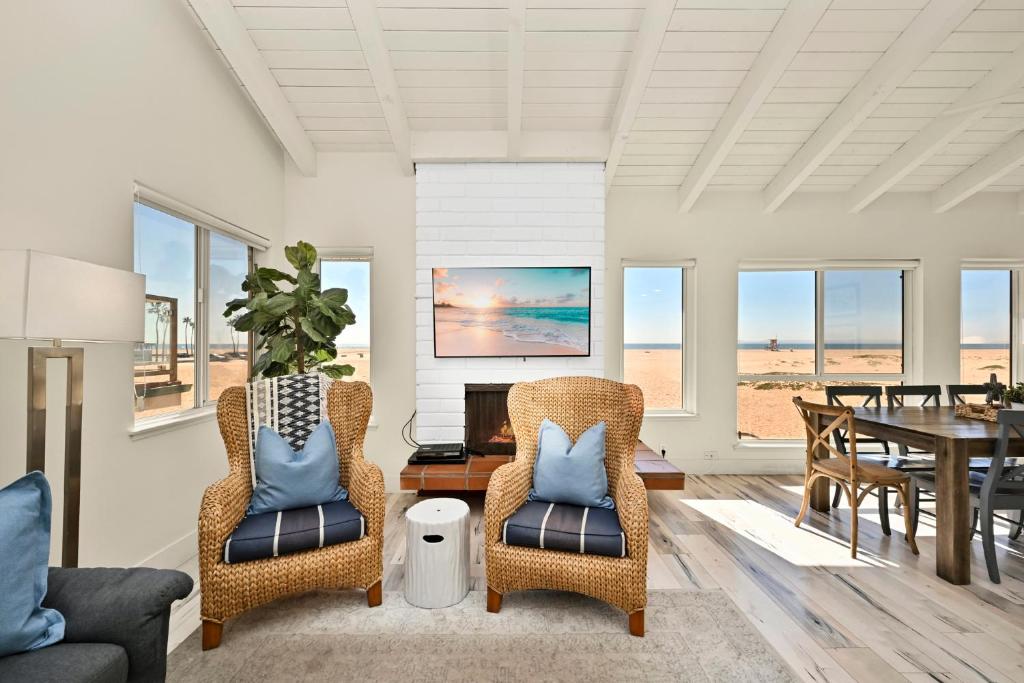 uma sala de estar com duas cadeiras e uma mesa em Beachfront home with Sweeping Ocean Views, AC, Walk to the Pier, Restaurants, Shops, Activities em Newport Beach
