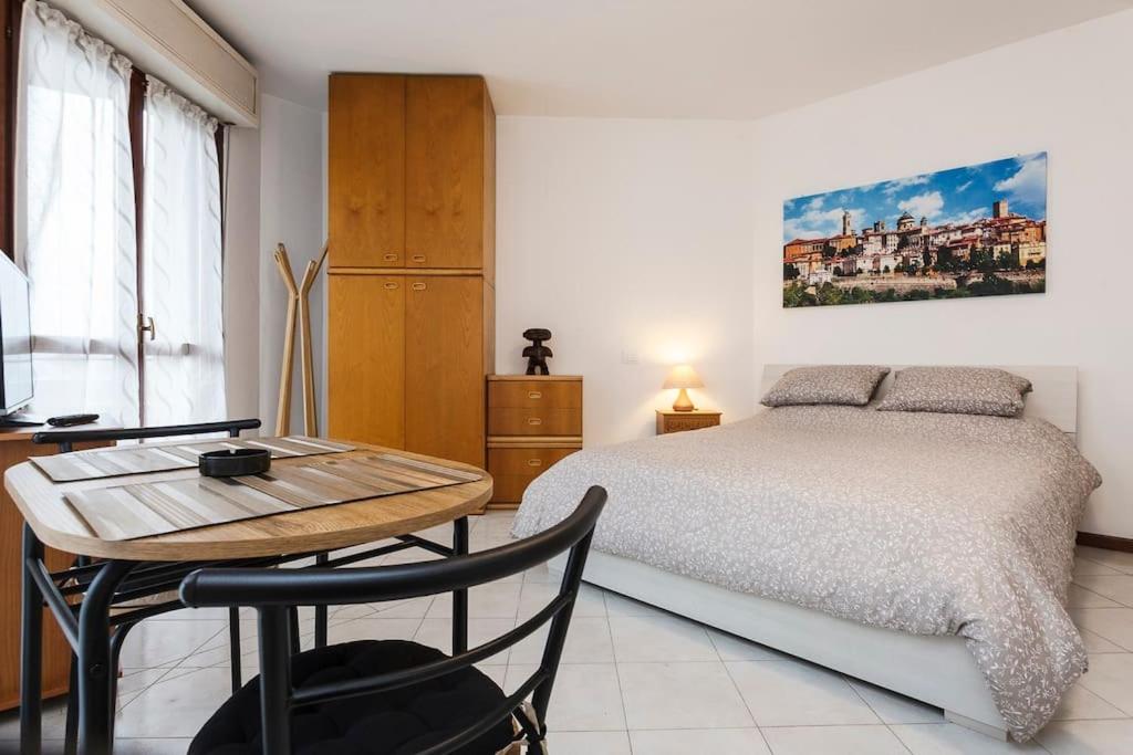 a bedroom with a bed and a table and a desk at Loft alto con vista su Città Alta in Bergamo