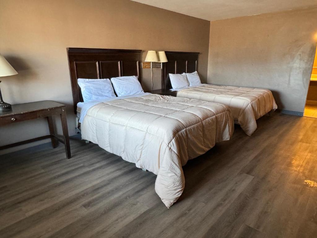 una camera d'albergo con due letti e un tavolo di Clintonville Motel a Clintonville