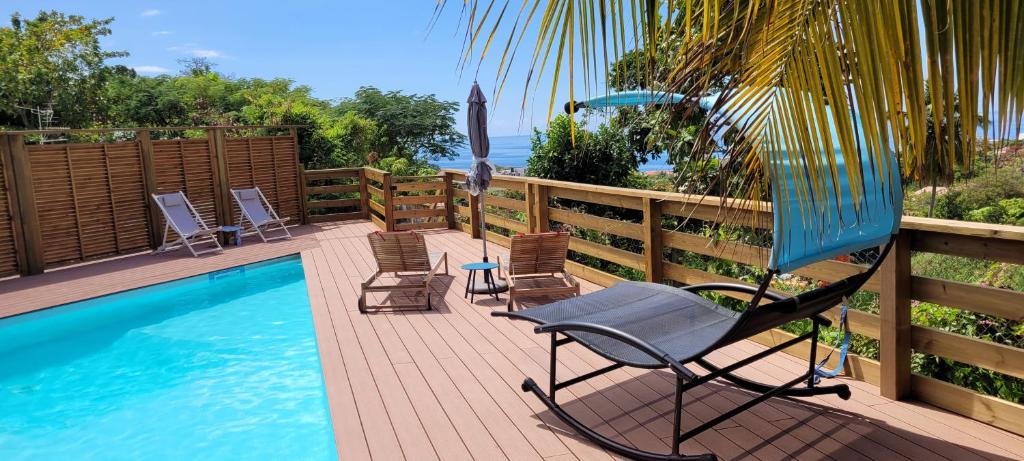 una terraza con una silla y una piscina en logement accès piscine, en Basse-Terre