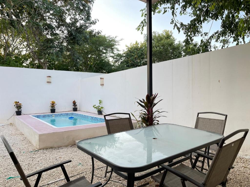 un patio avec une table et des chaises et une piscine dans l'établissement Kaab: Exclusividad y confort en un oasis vacacional con piscina, à Mérida
