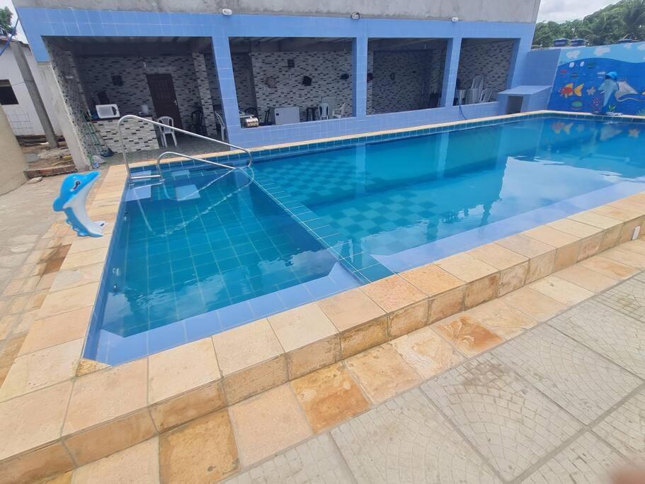 uma grande piscina com água azul em frente a uma casa em Casa mobiliada para hospedagens e com piscina para o lazer em Bayeux