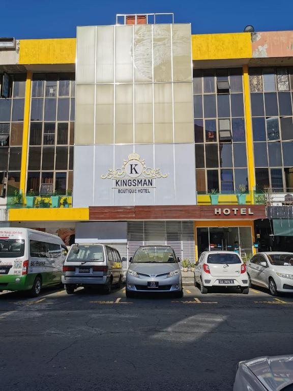 a parking lot with cars parked in front of a hotel at KINGSMAN BOUTIQUE HOTEL in Kota Kinabalu