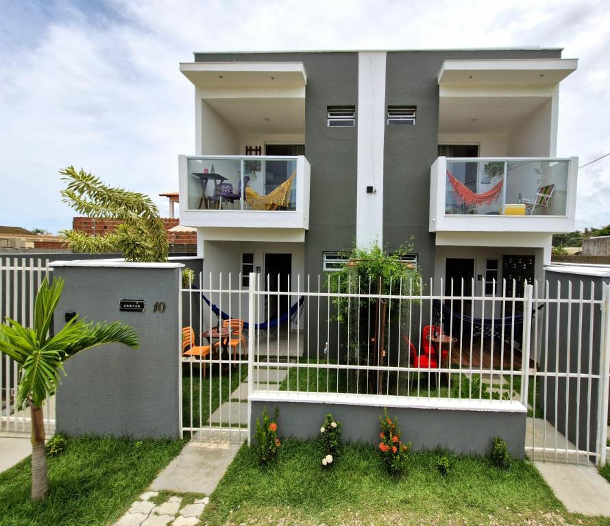 a white fence in front of a house at MSFlats Paripueira Aconchegante, Moderno Praia Mansa in Paripueira