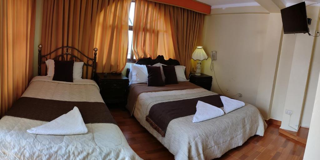 Cette chambre comprend 2 lits et une fenêtre. dans l'établissement Krusty Hostel II, à Huaraz