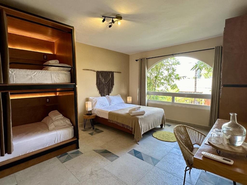 坎昆的住宿－Pachamaya - Suites, Wellness & Spa, Retreats，一间卧室设有两张床和大窗户