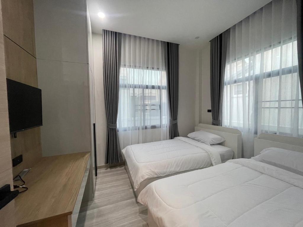 Habitación de hotel con 2 camas y TV en SS Home, en Ban Don Wai