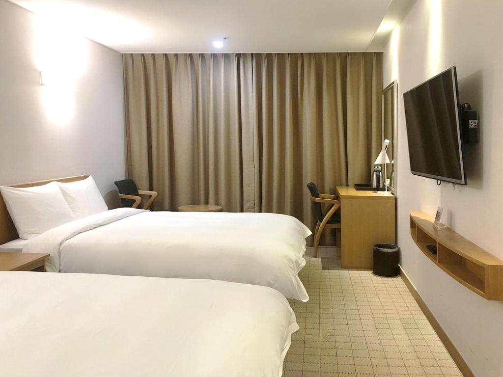 Postel nebo postele na pokoji v ubytování Jeju Hotel the M