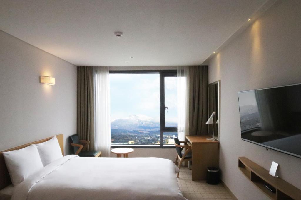 Postel nebo postele na pokoji v ubytování Jeju Hotel the M