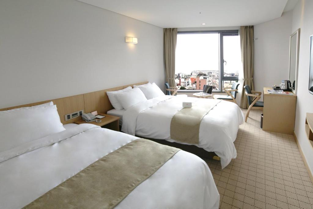 Postel nebo postele na pokoji v ubytování Jeju Hotel the M
