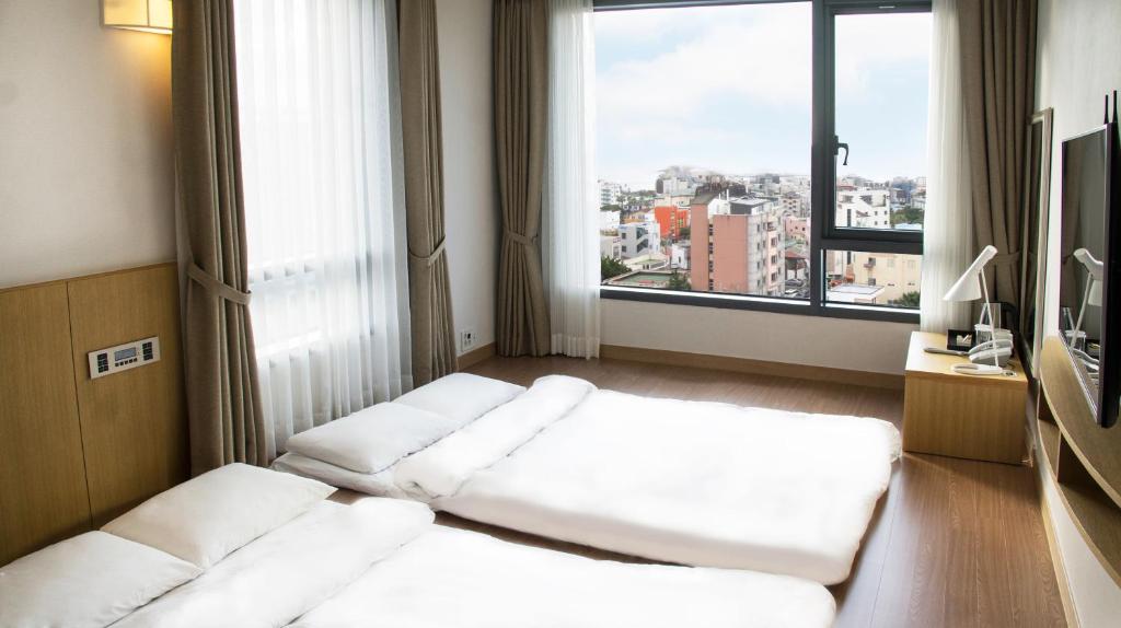 Postel nebo postele na pokoji v ubytování Jeju Hotel the M
