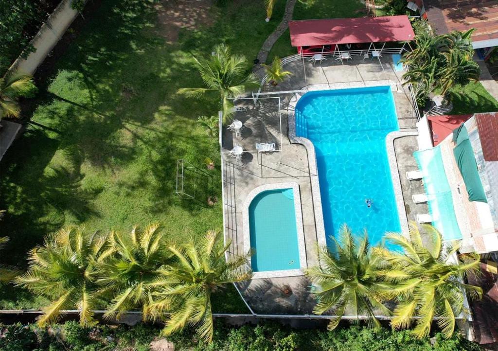 een uitzicht over een zwembad met palmbomen bij La Tranquera in San Ramón