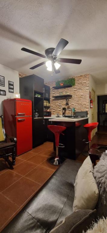 cocina con nevera roja y taburetes rojos en Bonito Loft Capri, 5 m Consulado en Ciudad Juárez