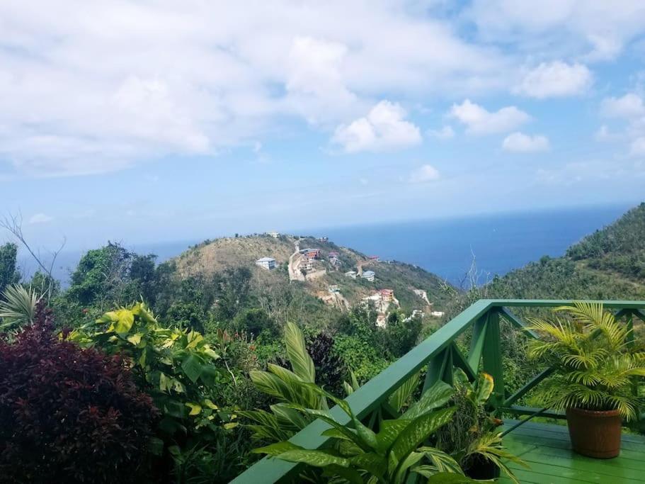 a view of a mountain with the ocean in the background at OCEAN VIEW VILLA, Tortola, British Virgin Islands in Tortola Island